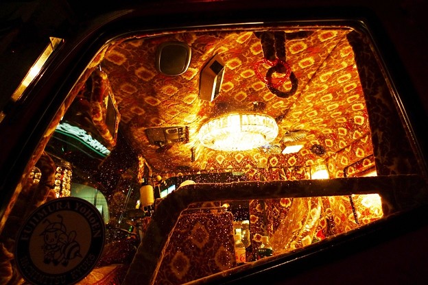 The interior of a Dekotora truck, with a chandelier and a carpet ceiling.